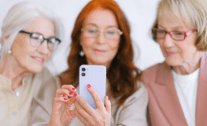 Acessibilidade. Imagem com 3 senhoras mexendo no celular