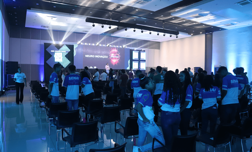 Inclusão. Imagens da plateia do evento assistindo a uma palestra.