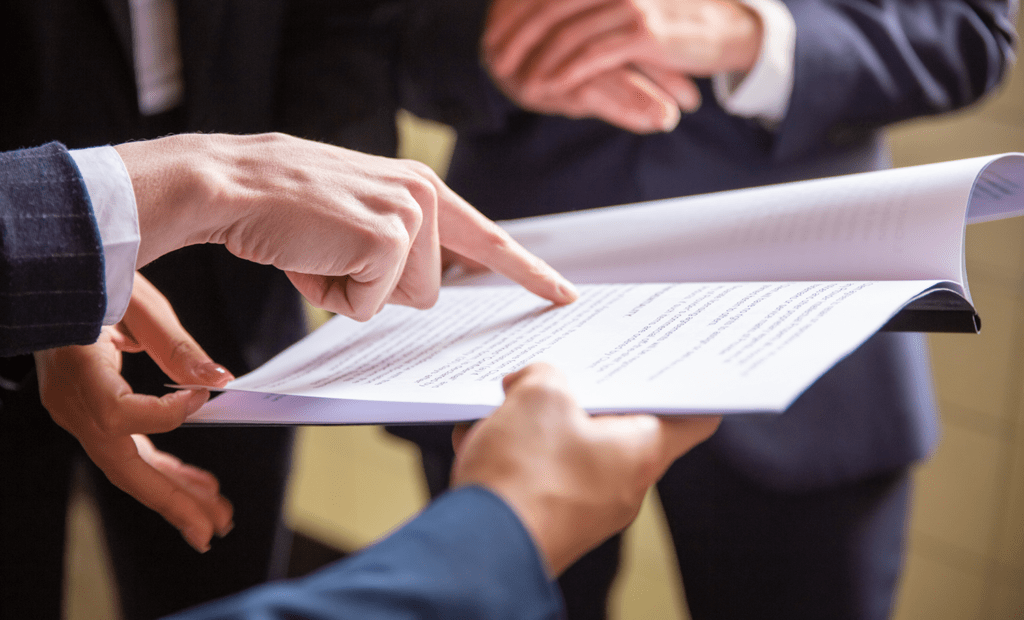 inclusão. A imagem representa pessoas de terno e gravata segurando um documento na mão, uma das pessoas aponta para o papel como se tivesse lendo.