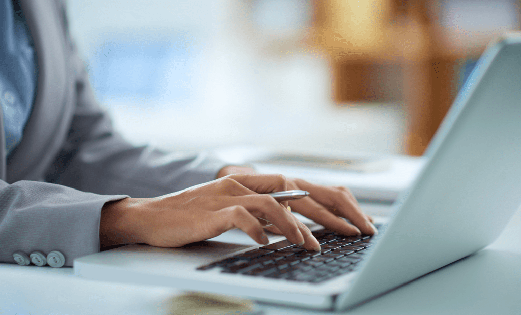 Diversidade. Uma mão feminina e branca mexendo em um notebook. 