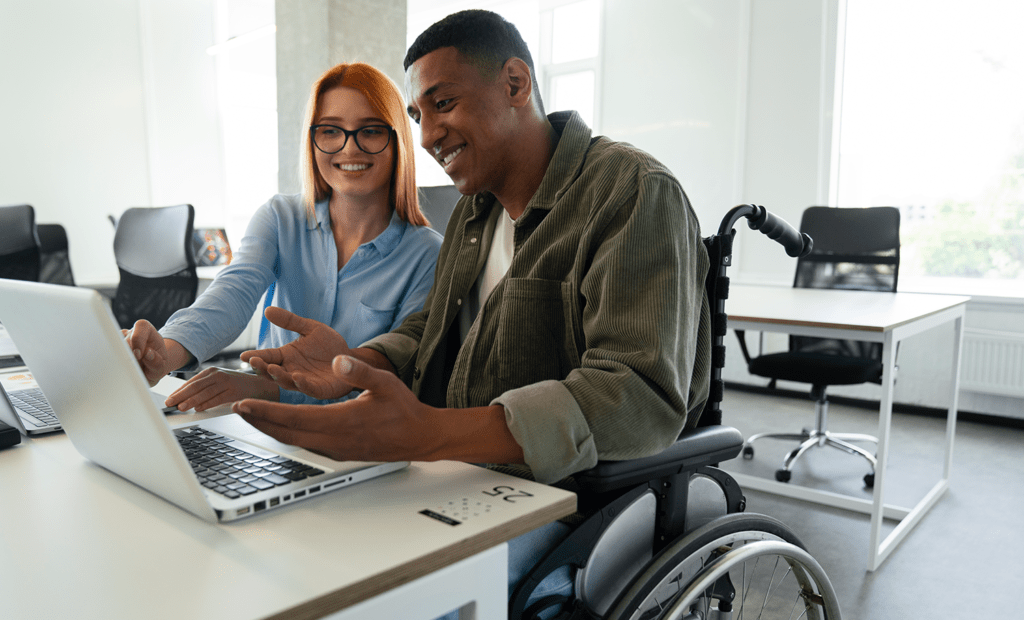 Campanha. Imagem de uma menina ruiva sentada mexendo no computado e ao lodo um menino negreo e cadeirante observando ela escrever,
