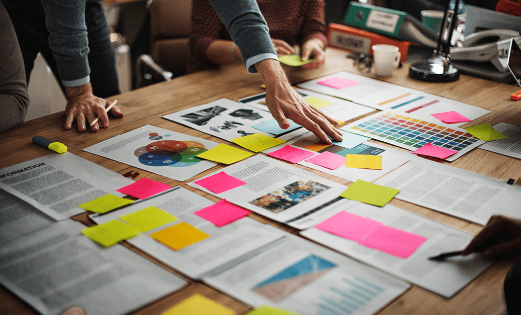 Empresa. Imagem de uma mesa de reunião cheia de papeis.