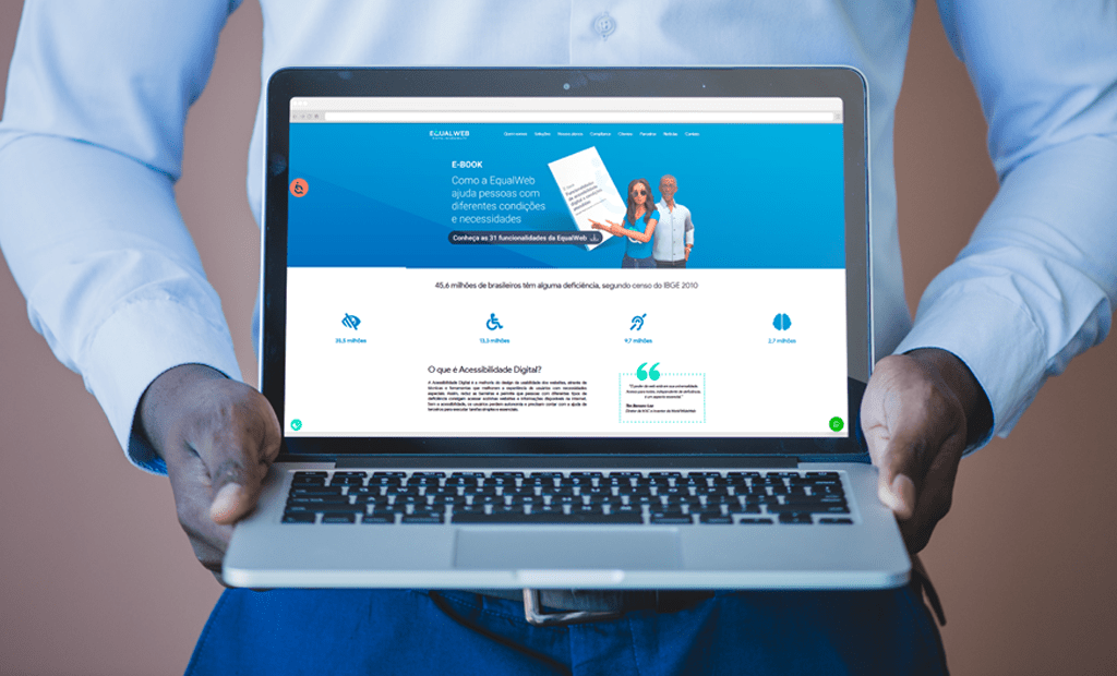 Inteligência. Imagem de um homem negro segurando um notebook com a tela aberta na página inicial da EW. 