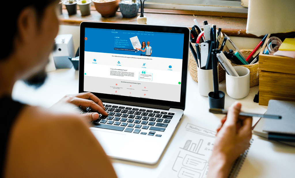 acessibilidade digital. Imagem de uma mulher mexendo no notebook e ele aberto na página do site da EqualWeb.