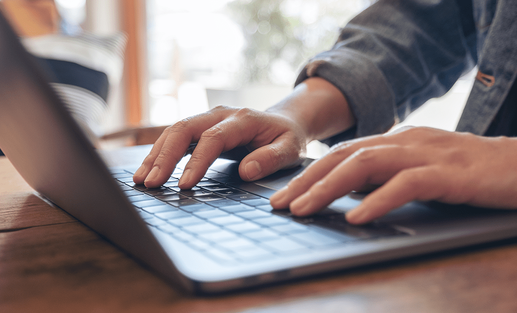 Acessibilidade. A imagem da tela é uma pessoa digitando no notebook.