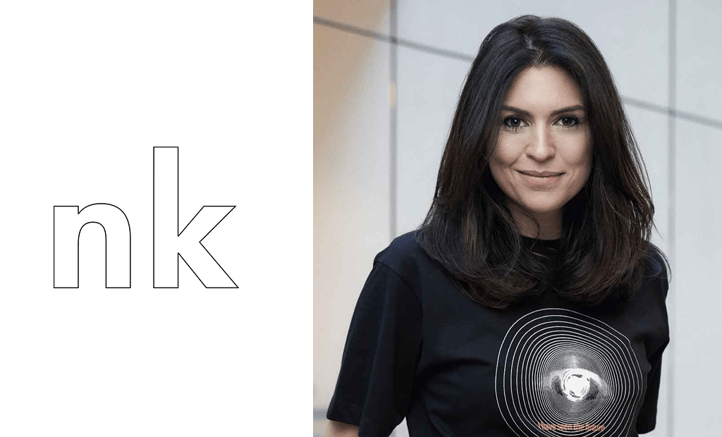 À esquerda, temos o logotipo da NK Store e, à direita, representando a liderança feminina da NK Store, temos a foto de Natalie Klein. Sua descrição física é de uma mulher branca com cabelos pretos, vestindo uma blusa preta.