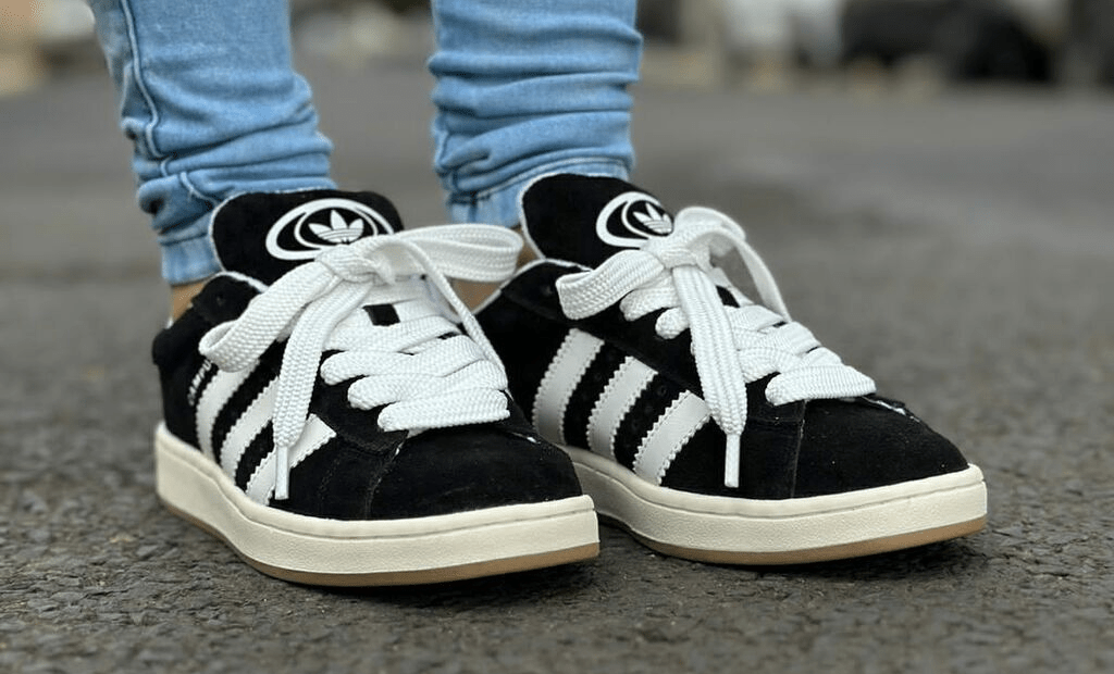 Descrições. Par de tênis Adidas Campus 00s, cor preto, com solado e cadarços brancos.