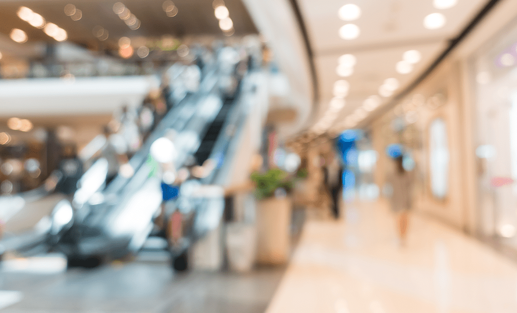 Shoppings. Imagem embassada de um corredor de shopping.