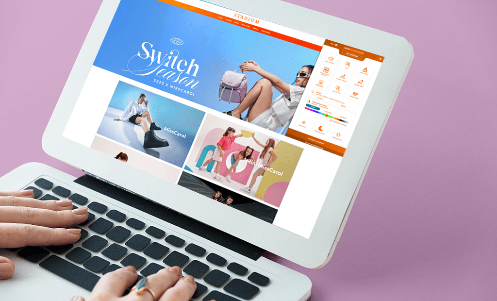 ROI. Laptop com uma tela exibindo o site da Stadium. O laptop está apoiado sobre uma superfície rosa, e as mãos de uma pessoa interagem com o teclado.