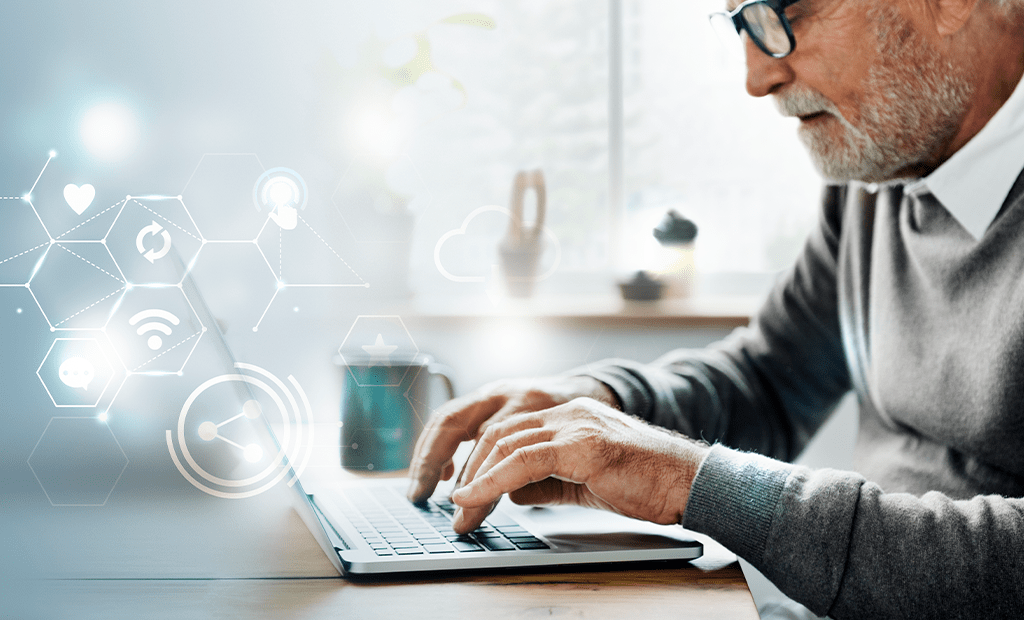 WCAG. Homem idoso digitando em notebook com ícones tecnológicos flutuantes, em ambiente iluminado por janela.