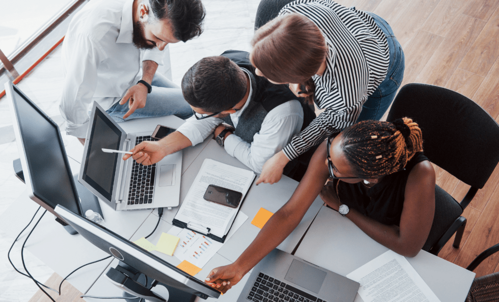 diversidade e inclusao nas empresas: grupo de pessoas olhando para o computador e e conversando entre si