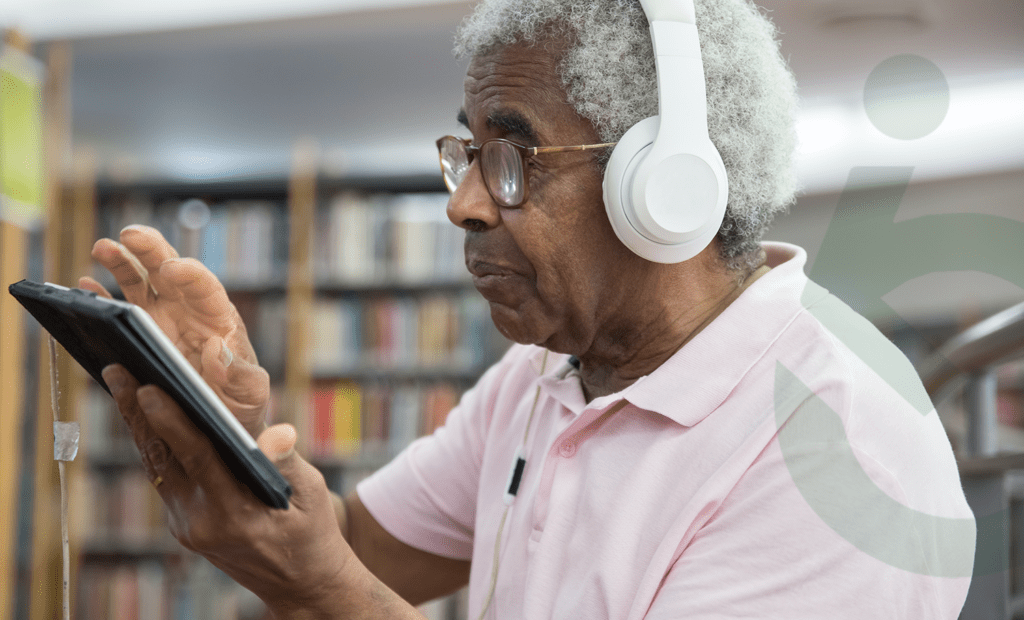 Acessibilidade. Senhor de idade negro mexendo no tablet com um fone de ouvido