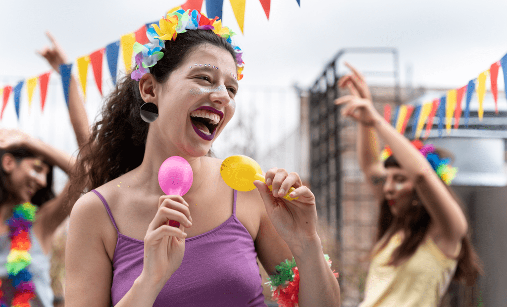 Carnaval. Imagem de 3 mulheres pulando carnaval de rua.