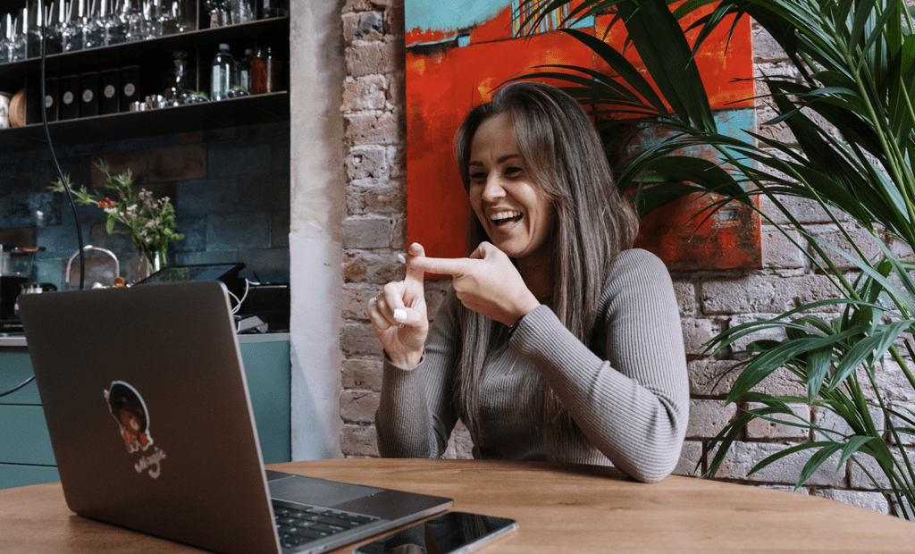 Conscientização. Imagem de uma mulher morena e de cabelos longos, fazendo um call em frente a um notebook.