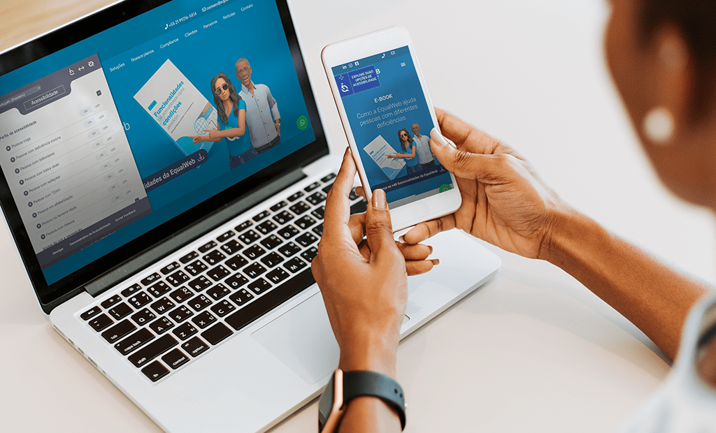Responsividade. Imagem de uma mão feminina segurando um celular com o site da EqualWeb aberto e a sua frente um notebook também com o site da EqualWeb aberto